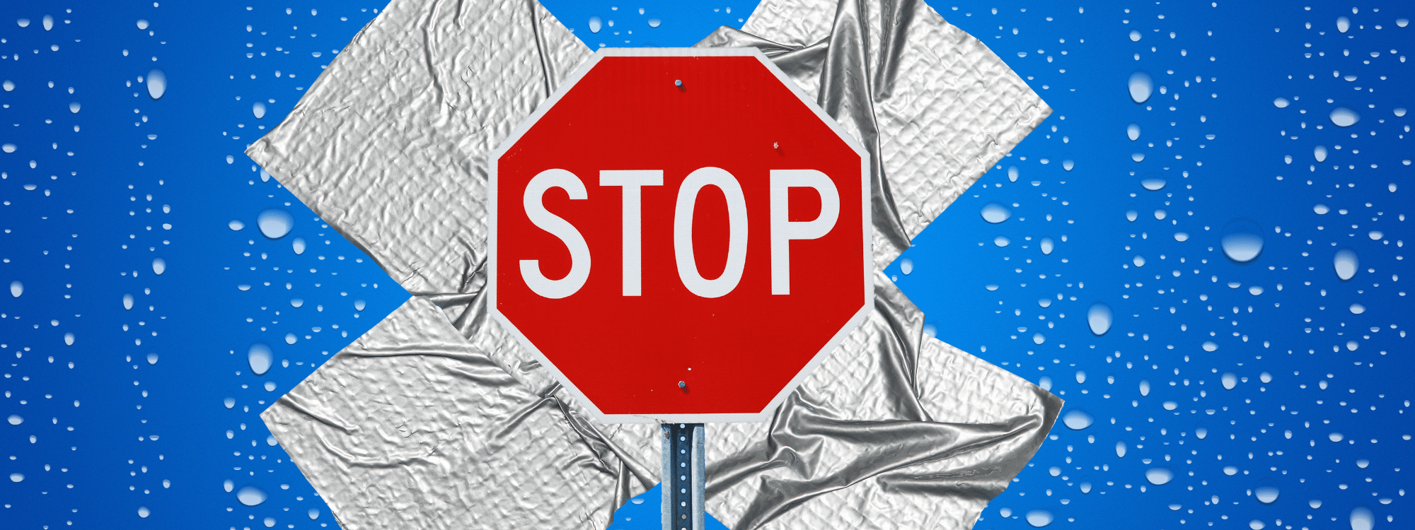 red stop sign with duct tape behind it forming an x with water droplets